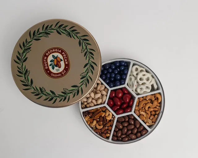 Seventh Heaven Tin filled with assorted nuts, chocolates, and snacks in a decorative container.